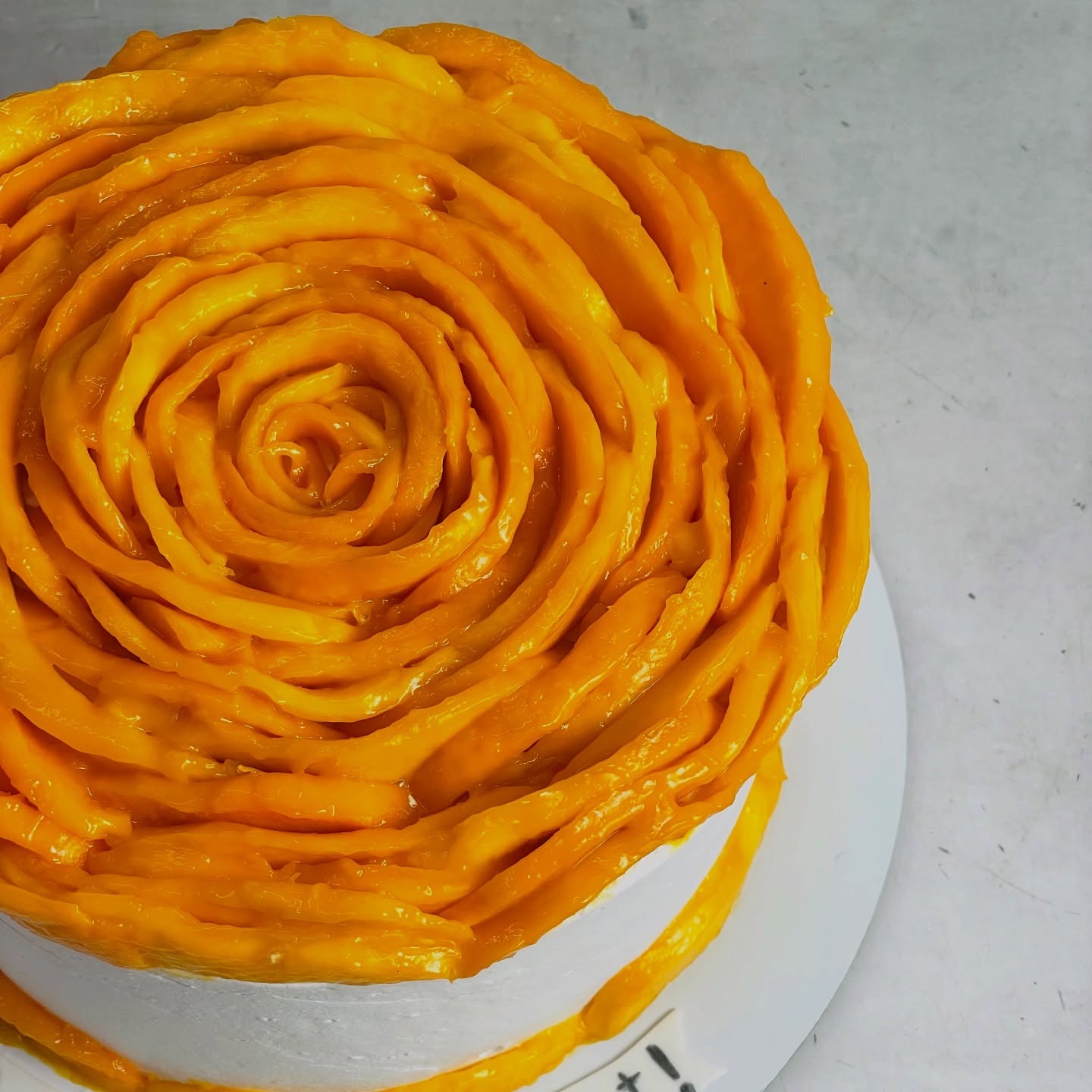 Cake topped with bright mango swirls