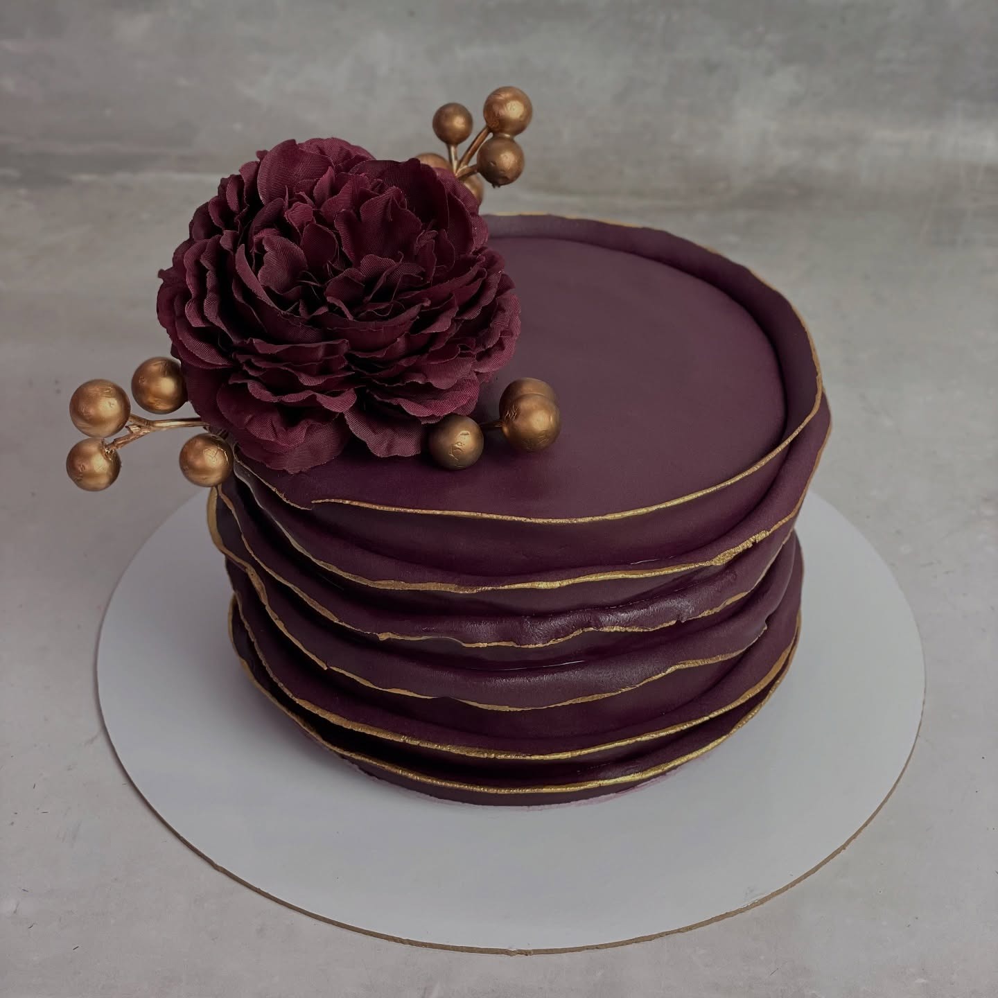 Elegant plum-coloured cake with a floral detail